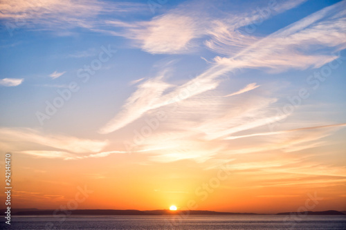 Sunrise with Sun, Blue Sky, Clouds and Sea photo