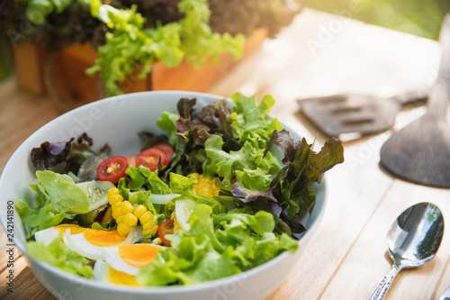 Fresh healthy salad on wooden table . Healthy eating, food, dieting and vegetarian concept - close up of vegetable salad in white bowl.