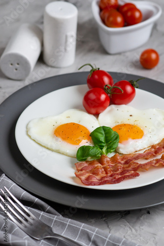 Tasty Fried Egg in the Shape of a Heart Served on a White Plate with Bacon Tomato Basil Pepper Gray Background Valentine Day Morning