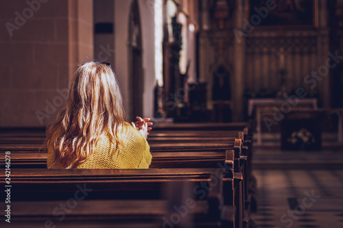 Young woman praying and meditating in church