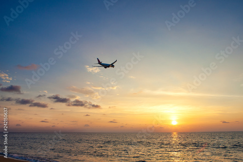 Airplane flying above sea at sunset © takoburito