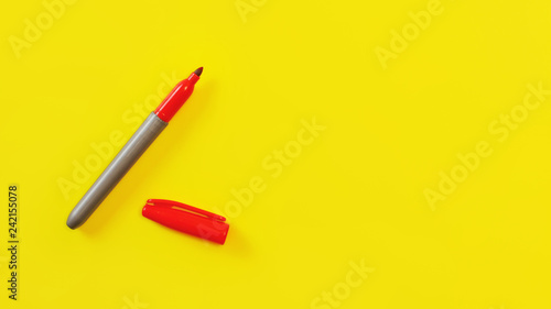 Top view on red marker, cap opened, on yellow board, copyspace for your text on right side.