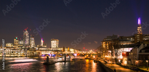 London Skyline at Night with Thames River  Bridges  City Buildings and Riverboats Crossing