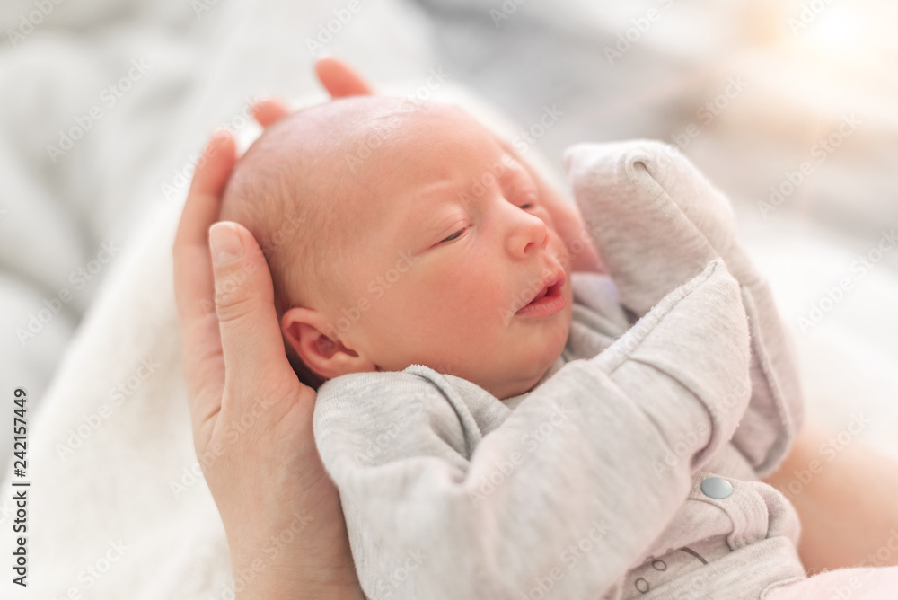 Baby in the hands of mom close up.