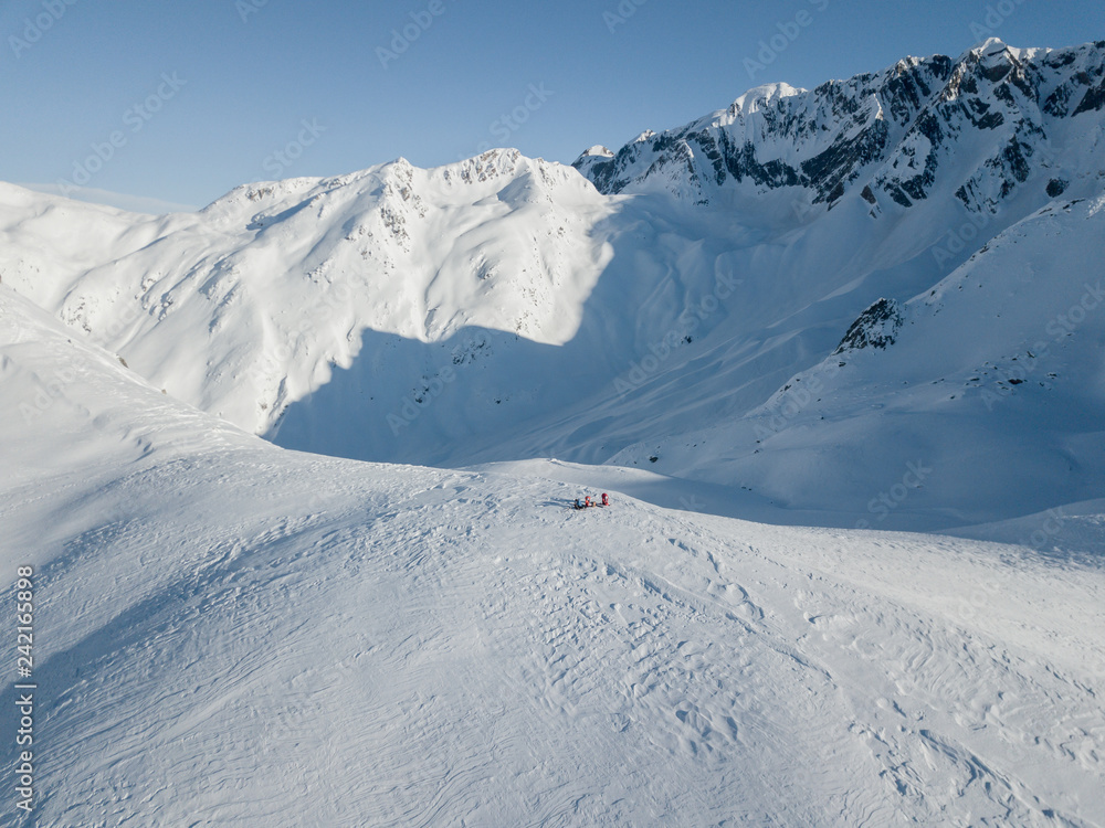 Aerial view of group of mountaineers on ridge in swiss alps during ski tour in backcountry Aerial view of group of mountaineers on ridge in swiss alps during ski tour in backcountry