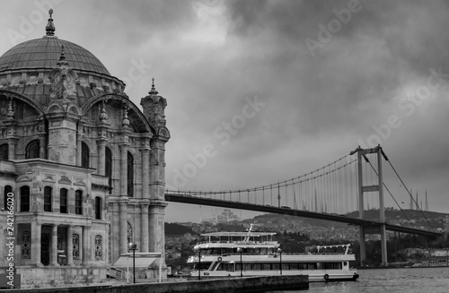 Istanbul, Turkey. 06-December-2018. Scenic black and white photo of Ortakoy mosque and bridge during a cloudy day