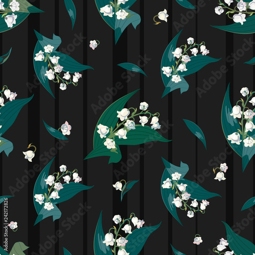 Lilly of the valley - May bells, Convallaria majalis with green leaves on a dark striped background.