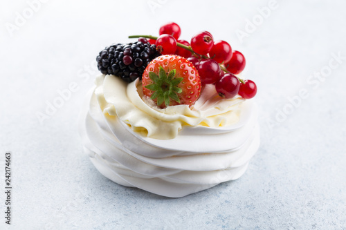 Beautiful pavlova cake with berries (strawberries, raspberries, blackberries, red currant) on a white background. photo