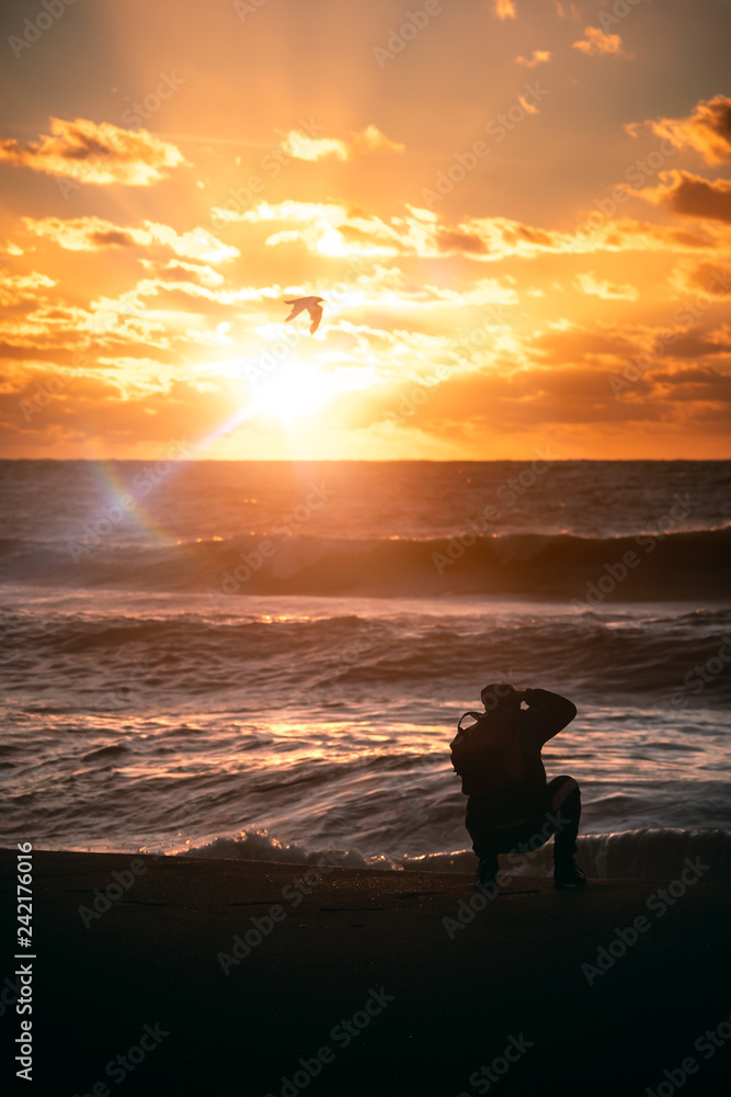 silhouette of a photographer on the beach at sunset silhouette of a photographer on the beach at sunset