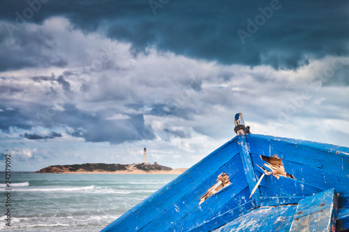 Old boat arrives with immigrants from Africa to the beach of Los Caños de Meca, Cadiz province, Spain