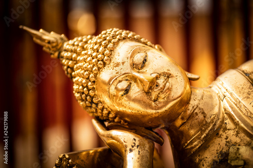 Face of a golden Tuesday Buddha statue. © enolabrain