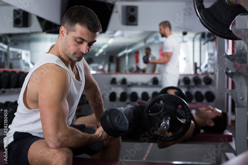 Man exercising with dumbbells in gym