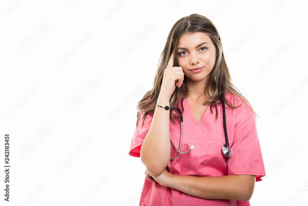 Portrait of beautiful young doctor wearing scrubs making thinking position Portrait of beautiful young doctor wearing scrubs making thinking position
