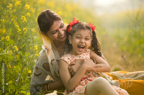Mother with daughter having fun at agriculture field