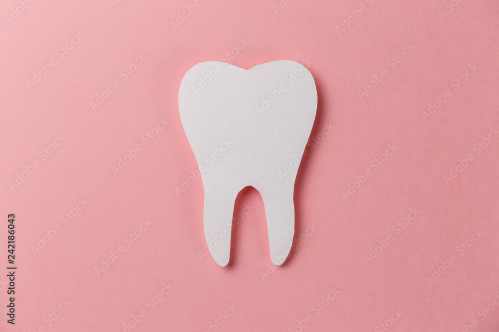 White tooth on pink background. Oral dental hygiene. Teeth whitening. Dental health concept. Oral care, teeth restoration. Dentist day concept. Flat lay. Top view. Pastel colors White tooth on pink background. Oral dental hygiene. Teeth whitening. Dental health concept. Oral care, teeth restoration. Dentist day concept. Flat lay. Top view. Pastel colors
