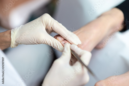 Closeup of professional esthetician making pedicure