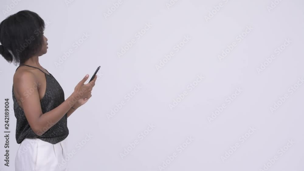 Young beautiful African woman getting lost and using phone for directions Young beautiful African woman getting lost and using phone for directions