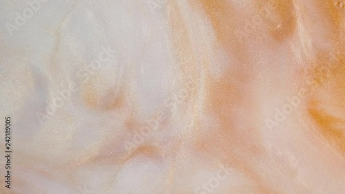 Colorful golden sand organically moves in colorful liquid