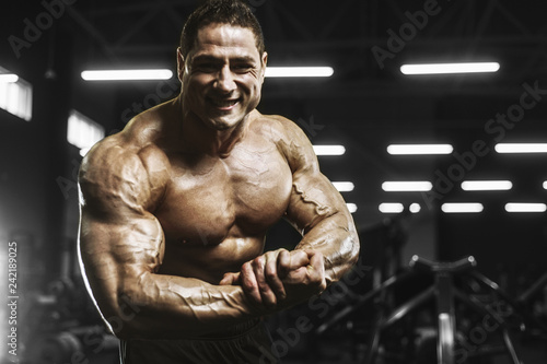 Handsome strong athletic men pumping up muscles workout bodybuilding concept background © antondotsenko
