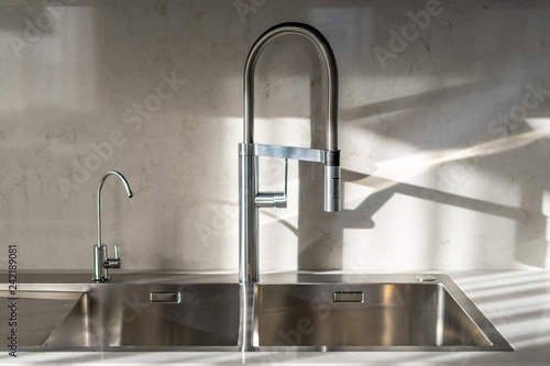 Steel water tap on comfort light bright kitchen