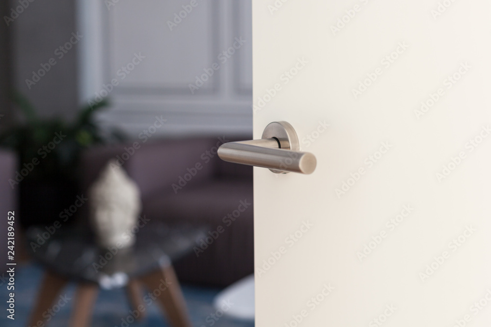 Naklejka premium Open white door with metallic handle. The door to the bedroom