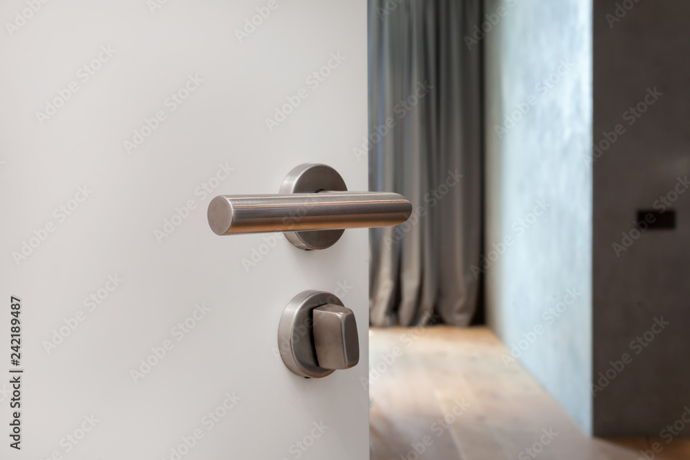 Naklejka premium Open white door with metallic handle. The door to the bedroom