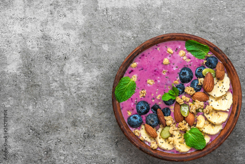 Healthy breakfast. acai smoothie bowl with banana, blueberry, granola, almonds, pumpkin and chia seeds photo