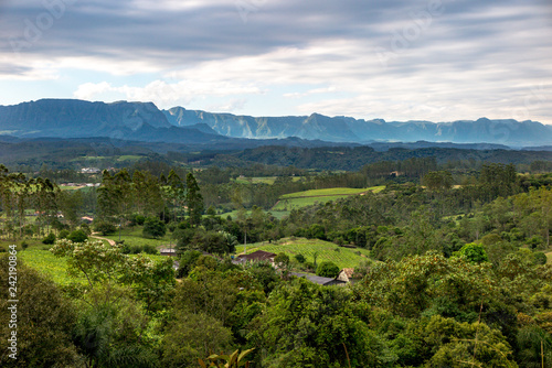 Panorama of the region of Lauro Muller, with pastures, forest and mountains of the National Park of Sao Joaquim in the background, cloudy sky, Santa Catarina