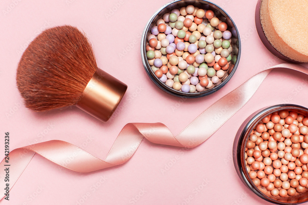 Ball pearl blush, face powder, makeup brush and pink ribbon on a pastel  pink background top view Flat Lay with copy space. Various cosmetic  products, Makeup Accessories. Stock Photo