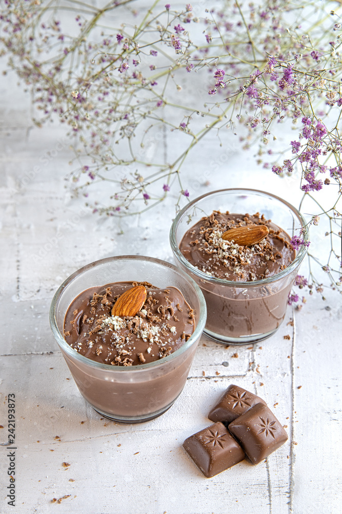 chocolate pudding with almonds on a light background decorated with flowers chocolate pudding with almonds on a light background decorated with flowers