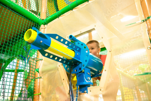 Obraz na płótnie Сhild plays in game center with blaster w salonie