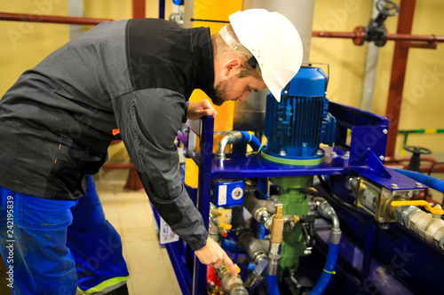 Obraz na płótnie Engineer checking oil pump and pressure gauge in industrial plant. w salonie