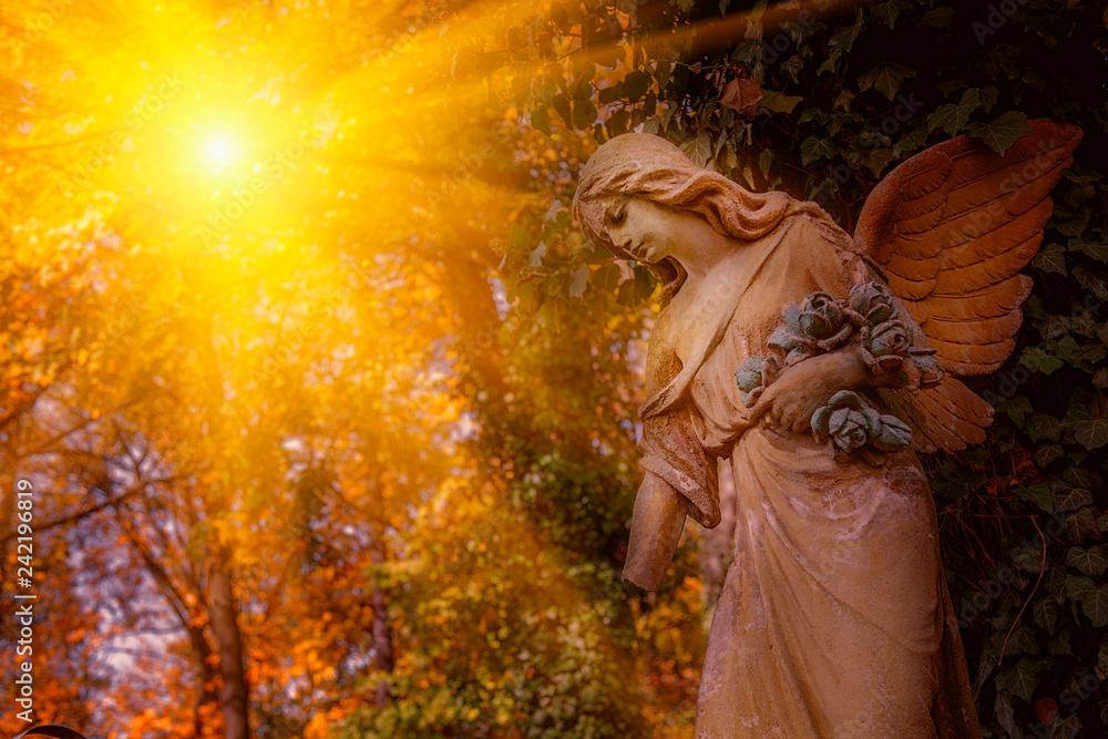 Antique statue of wonderful angel in the rays of the sun. Architecture, archetype, religion, faith concept. Antique statue of wonderful angel in the rays of the sun. Architecture, archetype, religion, faith concept.