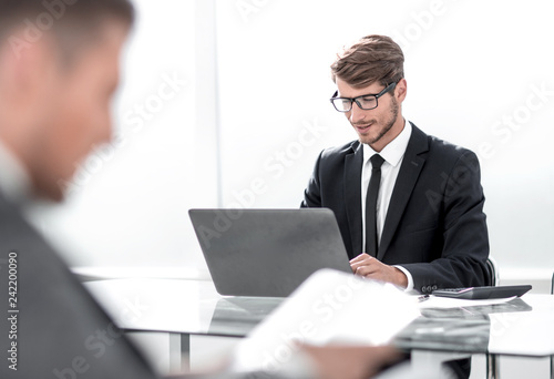 businessman in suit in office using tablet