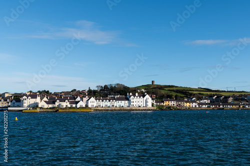 The colorful waterfront of  Portaferry with a hill and green fields above the village along Strangford Lough in County Down, Northern Ireland photo