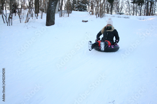 A Young Woman Sledging Down Hill Bright and Joyful Winter Scene. Rides Down the Hill in a Sleigh. Funny Winter Holidays.