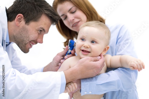 Doctor examining baby's ear with otoscope