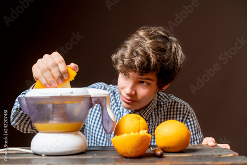 young man make juice with fresh orange b