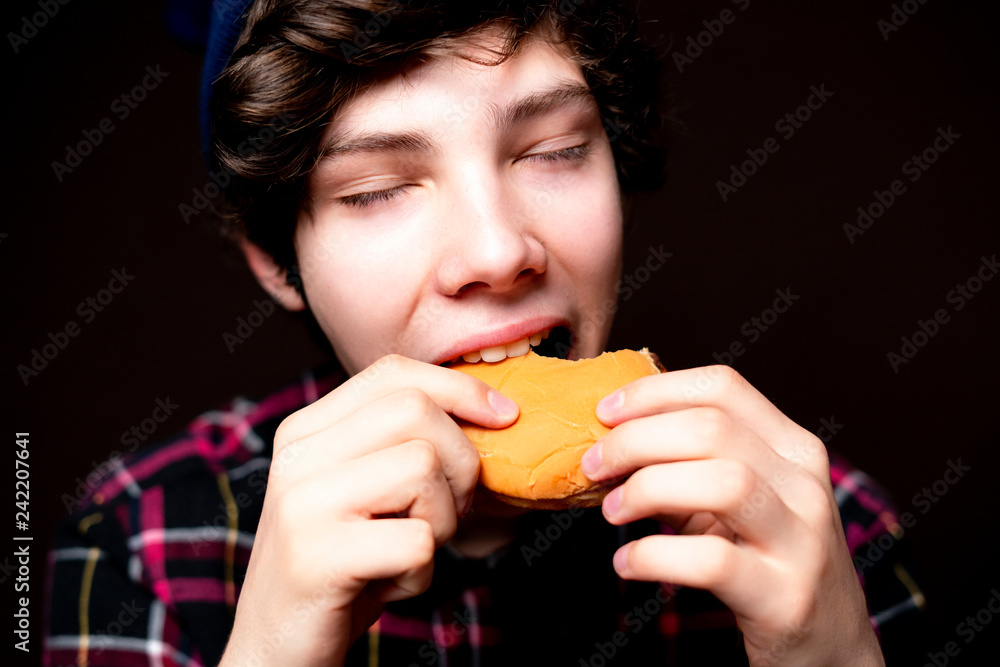closeup photo of mouth bite junk hamburger on dark background isolated b closeup photo of mouth bite junk hamburger on dark background isolated b