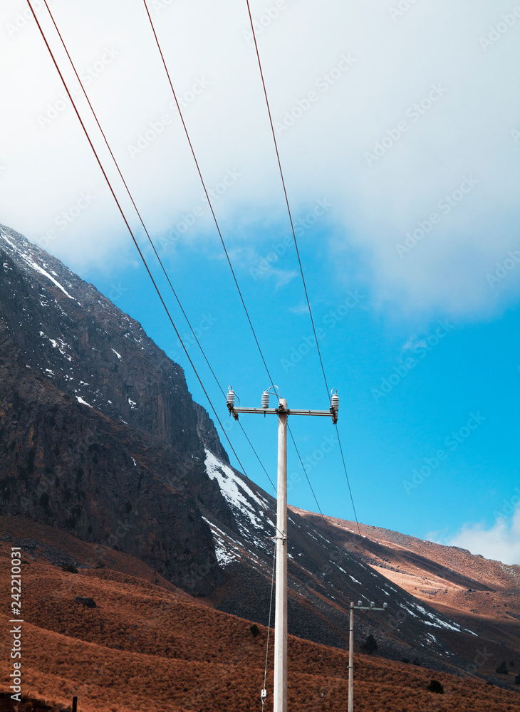 Poste / Postes altos de cables eléctricos - de energía simétricos en medio  de un paisaje de montaña