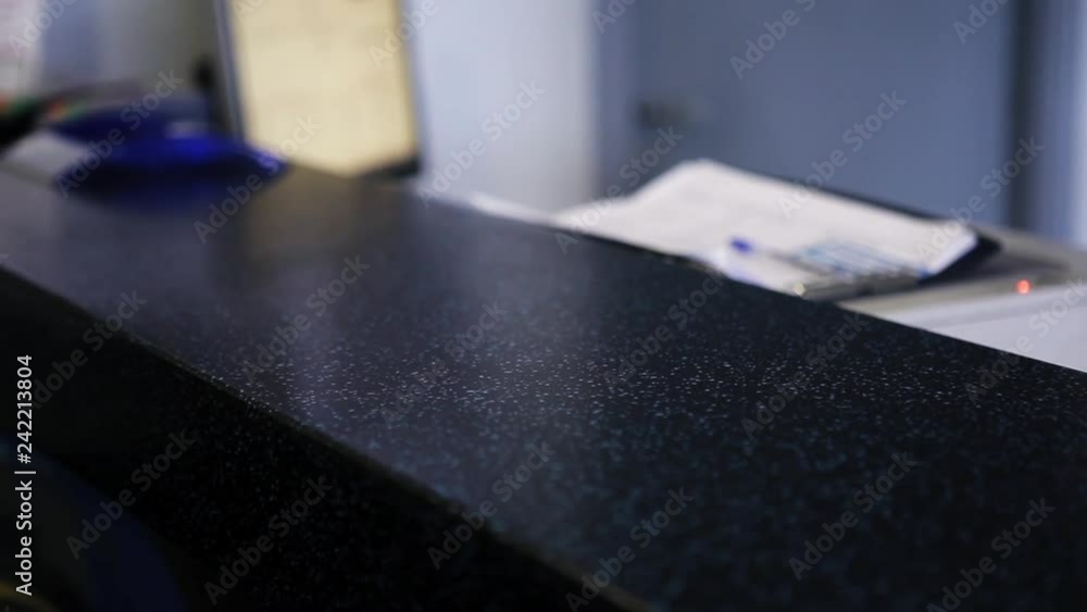 View of woman's hand with black nail polish puys key chain on desk surface and other woman's hand takes it immediately at some office room. View of woman's hand with black nail polish puys key chain on desk surface and other woman's hand takes it immediately at some office room.