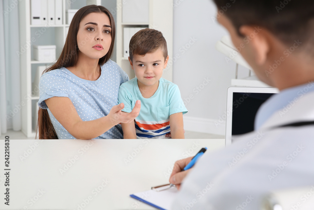 Mother and son visiting pediatrician. Doctor working with patient in hospital Mother and son visiting pediatrician. Doctor working with patient in hospital