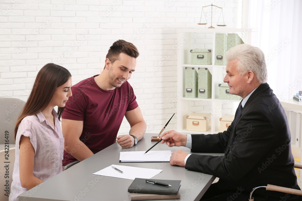 Lawyer having meeting with young couple in office Lawyer having meeting with young couple in office