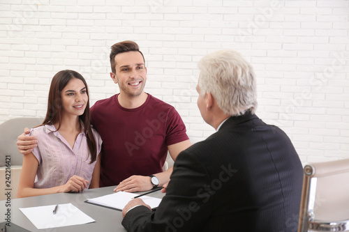 Lawyer having meeting with young couple in office photo