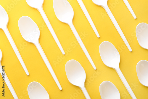 Plastic spoons on color background, top view. Picnic table setting
