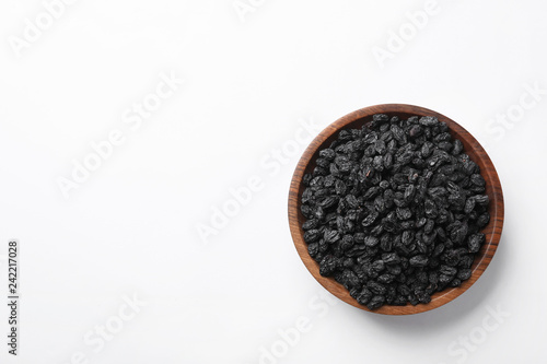 Bowl with raisins and space for text on white background, top view. Dried fruit as healthy snack