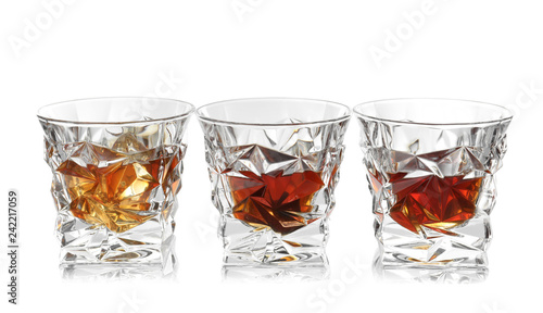 Glasses of scotch whiskey on white background