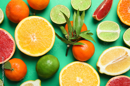 Different citrus fruits on color background, top view