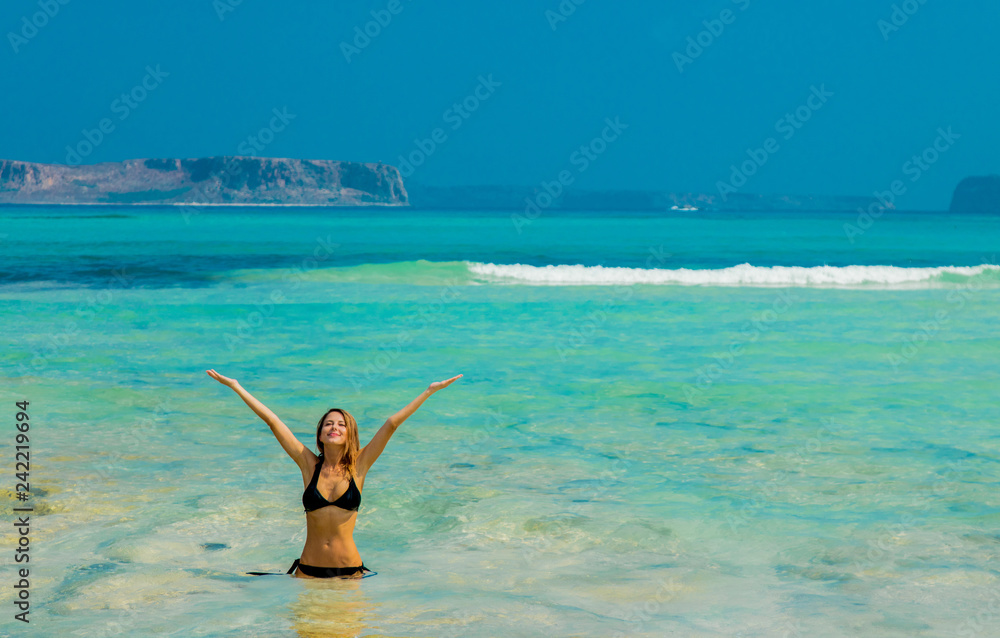 Young redhead girl in black bikini on Balos beach, west Crete, Greece.  Summertime season vacation, July Stock Photo | Adobe Stock