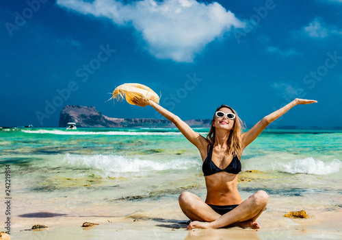 Young redhead girl in black bikini and with hat on Balos beach, west Crete, Greece. Summertime season vacation, July